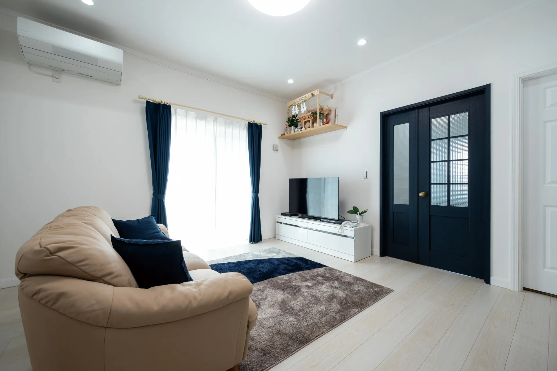 ベースカラーはご家族の意見を参考に明るい白を採用。扉やカーテンはネイビーで統一することにより、落ち着きのあるシンプルモダンな空間に仕上がりました。また、建て替え前は庭に増築した２階建てに遮られて十分な採光を得られていなかったため、現在の明るく居心地の良い住空間をとても気に入られているようです。