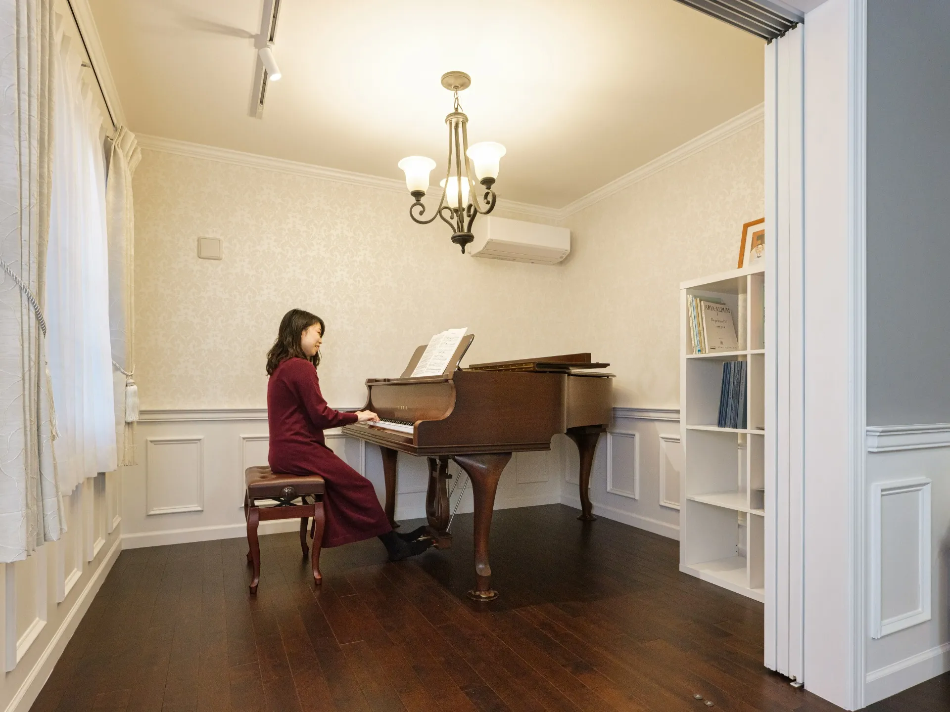 音楽の仕事に携わる夫人のためにご計画されたピアノ室。グランドピアノの重量に耐えられるよう、床補強工事を施しました。間仕切りには上吊りタイプの引き込み戸を採用し、デザイン性・安全性を確保。