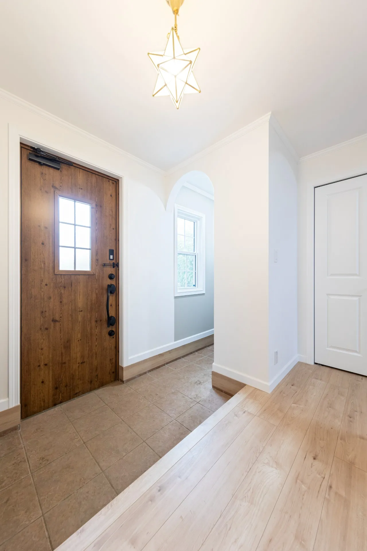 ２人並んで靴の脱ぎ履きが可能なほど、広さを確保した玄関。やわらかさを演出するアーチ壁の奥はシューズインクロゼットとなっており、隠したいものなどを格納することで、玄関はいつも美しい状態をキープ。