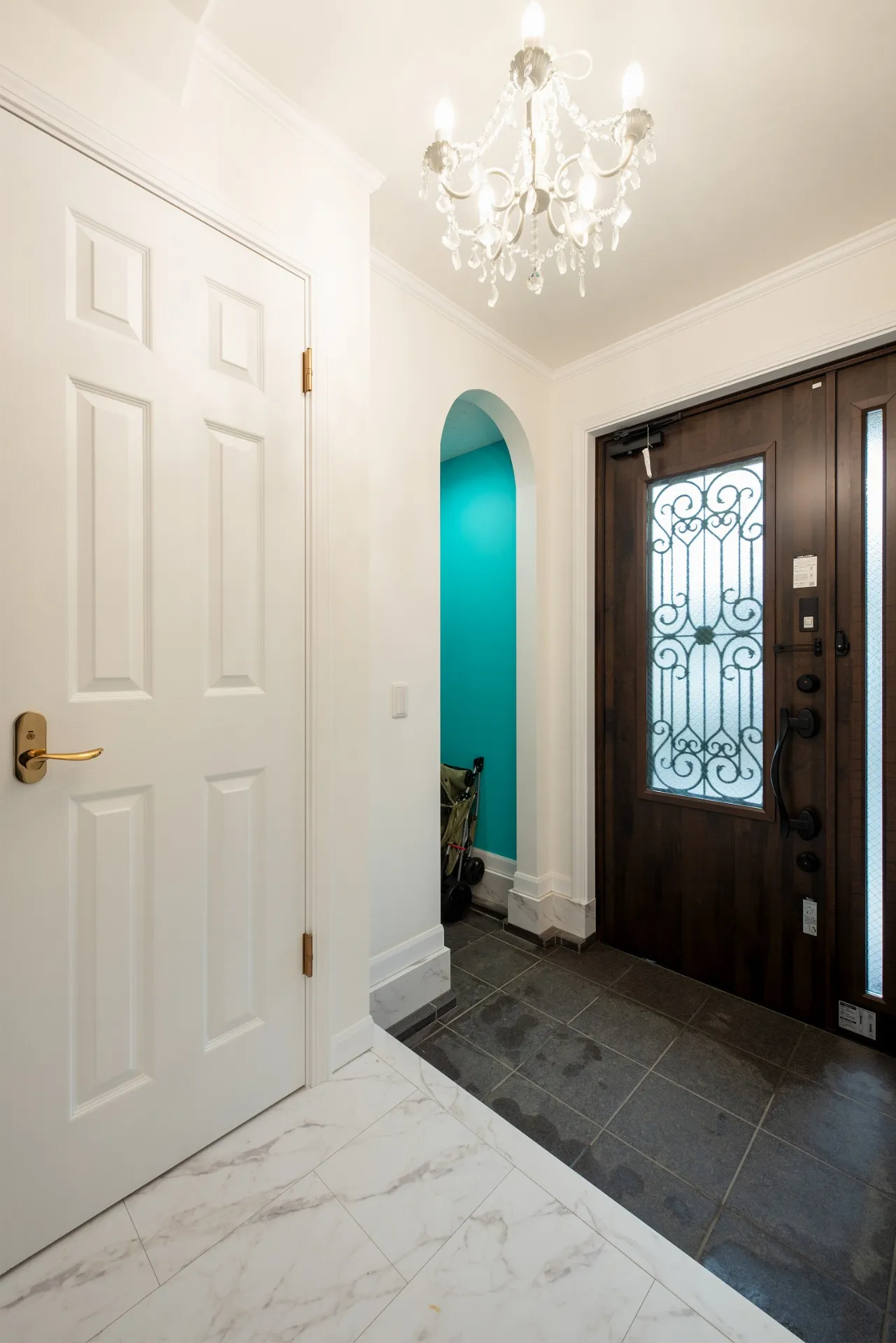 玄関に併設したシューズインクロゼットにも、アールの垂れ壁とターコイズブルーのアクセントクロスを採用。ワンポイントの差し色となり、基調としたホワイトをグッと引き立てている。照明はオーナー支給の品だが、気分を上げてくれるお洒落なドアなどは標準の中からチョイス可能なものを選択されました。