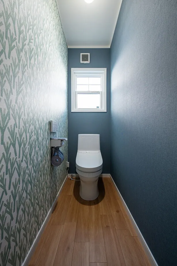 ブルー×ブラウンでコーディネートし、個性のあるアクセントクロスで他の空間とは一味違った雰囲気に。「以前リフォームを検討していた時のことを思い出し、『トイレは派手にしてみよう』とちょっと冒険しました」とお施主様。