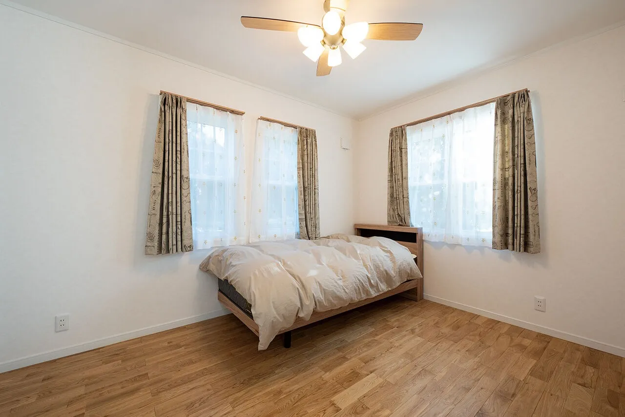 愛犬たちも集まってみんなで一緒に寝ている６帖の寝室。二面採光で明るく、景色も良く見える心地よい空間です。リビングとの間にあえて廊下は設けず、３枚引き戸でつながるように設計されており、普段は扉を開けたままにして空間を広々と使っています。