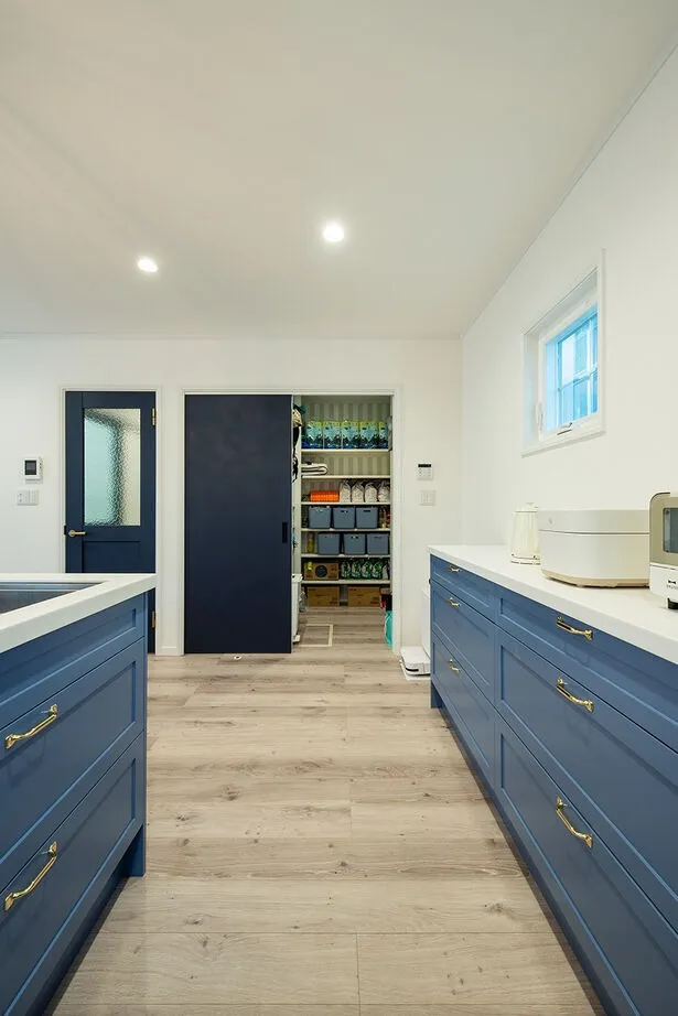 キッチンのすぐ近くに大容量のパントリーを配置。コの字型に棚を設けているので、ストック品を多めに買っても余裕の広さ。扉は猫が開けられないよう引き戸タイプを採用。キッチンにもたっぷり収納を備えているのでモノが外に出にくく、常にすっきり片付いている